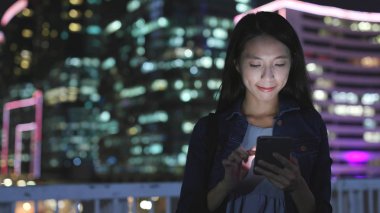 Geceleri cep telefonu kullanan bir kadın. 