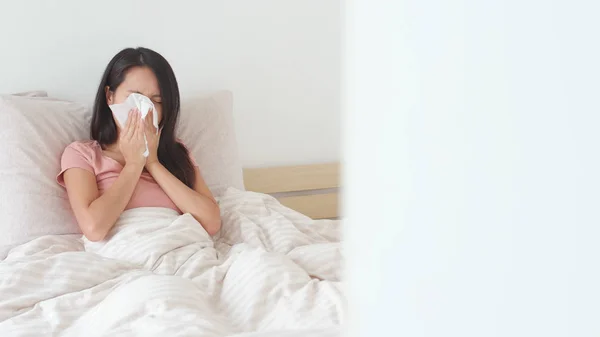 Žena, kýchání na posteli — Stock fotografie