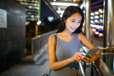 Gece akıllı telefon kullanan bir kadın. 