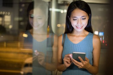 Smartphone şehirde geceleri kullanan kadın 