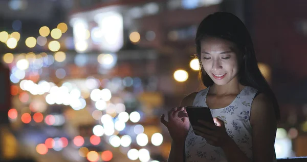 Mulher trabalhando no celular na cidade à noite — Fotografia de Stock