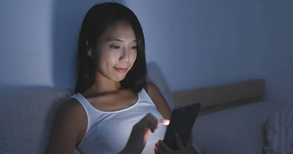 Женщина, использующая мобильный телефон ночью в постели — стоковое фото