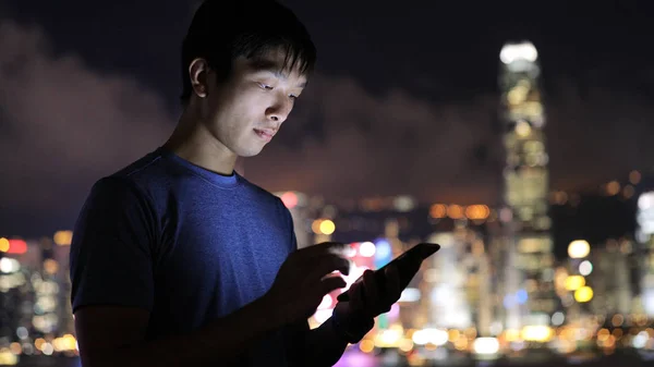 Asiático homem usando celular à noite — Fotografia de Stock