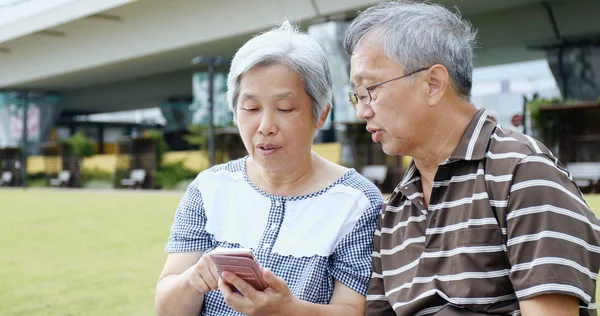 Couple using mobile phone together — Stock Photo, Image