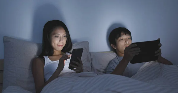Pasangan menggunakan ponsel dan tablet secara terpisah — Stok Foto