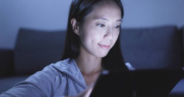 Geceleri tablet bilgisayar kullanan kadın 