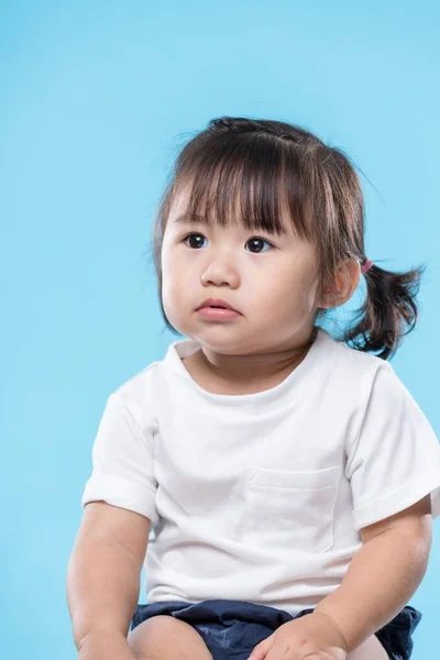Baby Flicka Tittar Upp Blå Bakgrund — Stockfoto