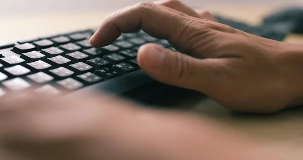 Mãos de homem digitando em um teclado de computador — Fotografia de Stock