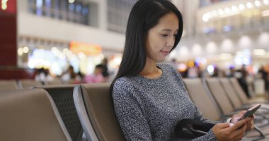 Havaalanında cep telefonu kullanan kadın 