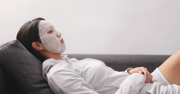 Wanita Mengenakan Masker Wajah Dan Berbaring Sofa — Stok Foto