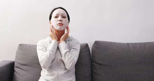 Frau Trägt Gesichtsmaske Auf Und Sitzt Auf Sofa — Stockfoto