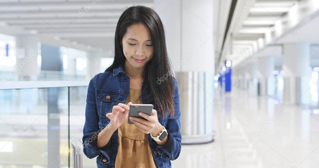 Woman using mobile phone in airport 