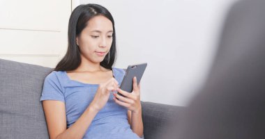 Evde akıllı telefon kullanan bir kadın. 