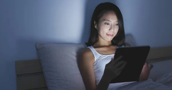 Mujer trabajando en Tablet PC en la cama —  Fotos de Stock