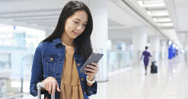 Жінка використовує мобільний телефон в аеропорту — стокове фото