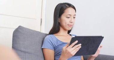 Divan tablet bilgisayarda çalışan kadın 