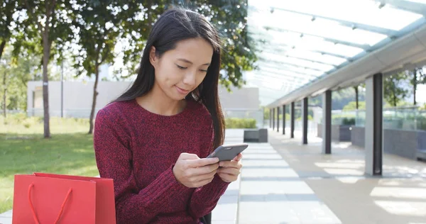 Kvinna med mobiltelefon med hennes väskor — Stockfoto