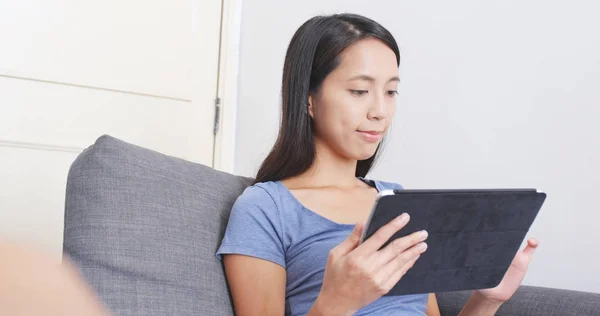 Женщина работает на планшетном компьютере на диване — стоковое фото