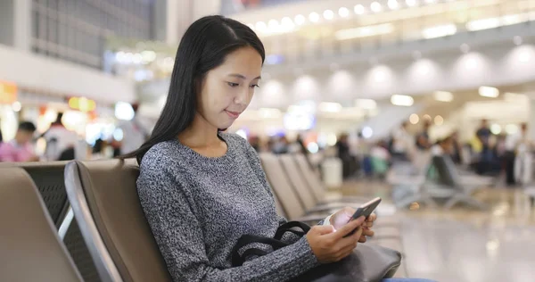 Mulher usando celular no aeroporto — Fotografia de Stock