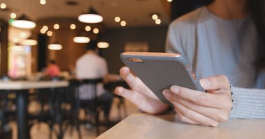 Kafede akıllı telefon kullanan bir kadın. 