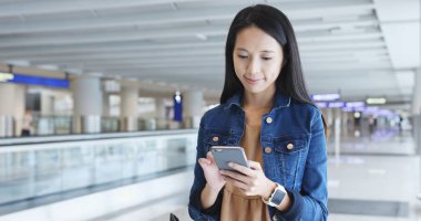 Havaalanında cep telefonu bakarak kadın 