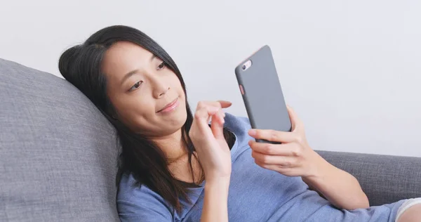 Frau liest zu Hause auf Handy — Stockfoto