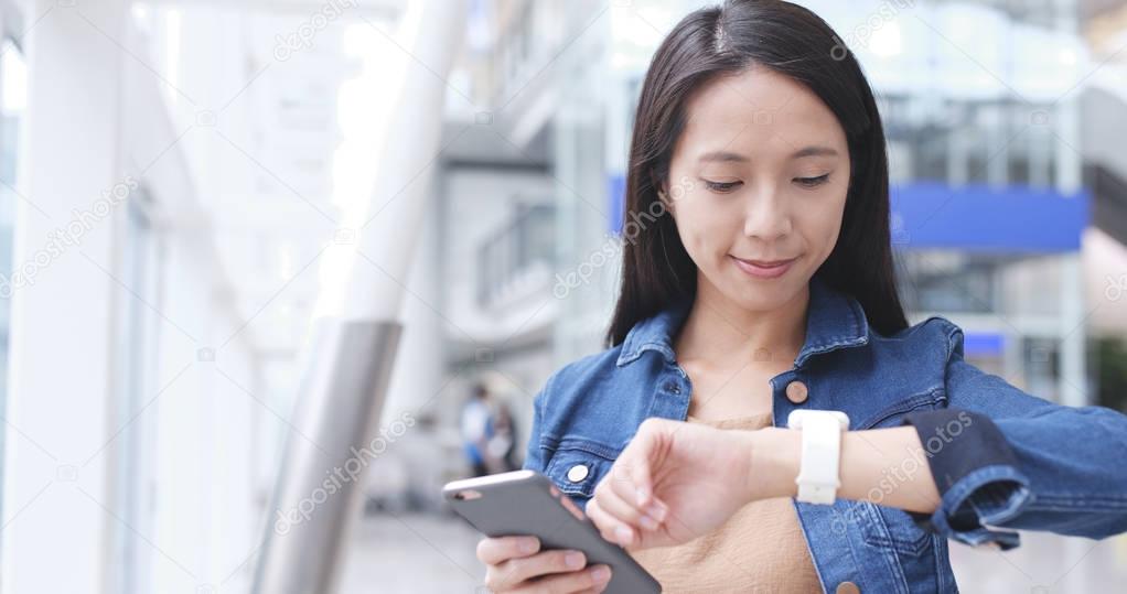 Woman using smart watch and cellphone 