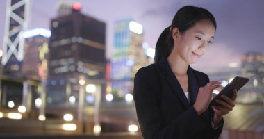 Gece akıllı telefon kullanan bir kadın. 