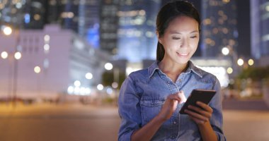 Geceleri cep telefonu kullanan bir kadın. 