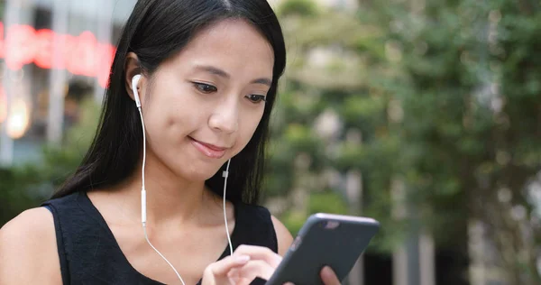 Woman listen to music on cellphone in the park