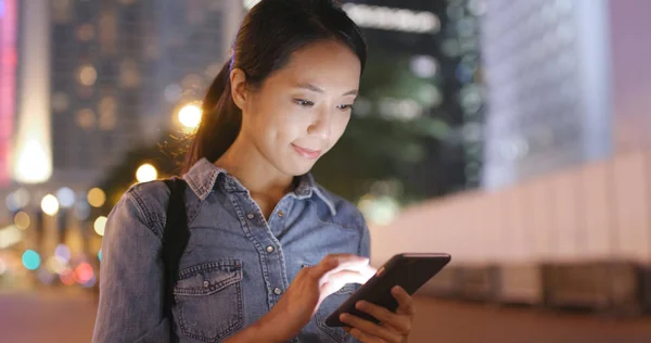 Kvinna som tittar på mobiltelefon i staden — Stockfoto