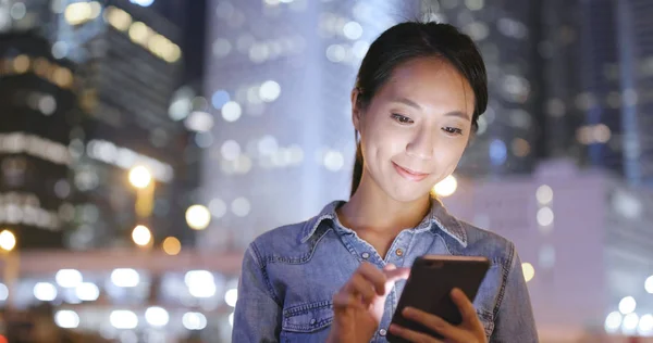 Mulher usando smartphone à noite — Fotografia de Stock