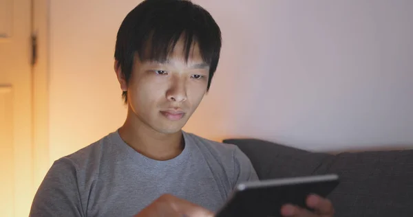 アジア人の男性が家でタブレットを使用して — ストック写真