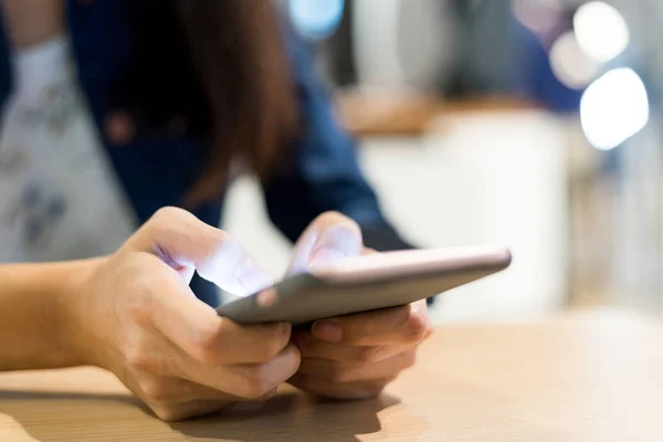 Vrouw met behulp van mobiele telefoon in restaurant — Stockfoto