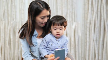 Anne oğlu ile cep telefonundan izlerken