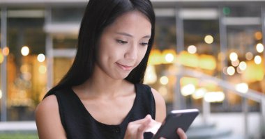 Sokakta cep telefonu kullanan kadın.