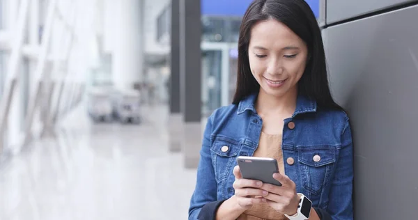 Woman looking at cellphone for time flight — Stock Photo, Image