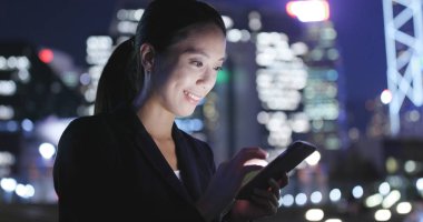 Geceleri cep telefonu kullanan kadın 