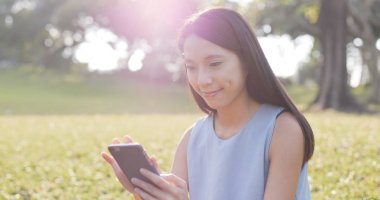 parkta cep telefonu kullanan kadın