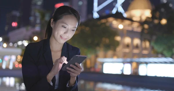Empresária usando smartphone na cidade à noite — Fotografia de Stock