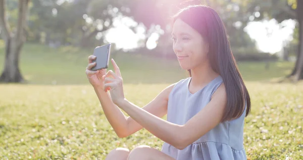 Frau fotografiert mit Handy im Park — Stockfoto