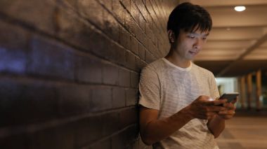 Geceleri cep telefonu kullanan adam