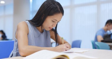 Kadının kitaplığındaki ödevini yapması 