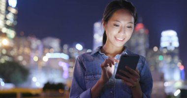 Geceleri cep telefonu kullanan bir kadın. 