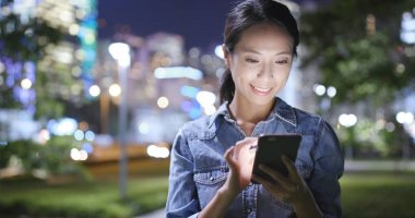 Geceleri smartphone şehir bakarak kadın