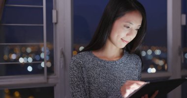 Tablet bilgisayarda geceleri çalışan kadın