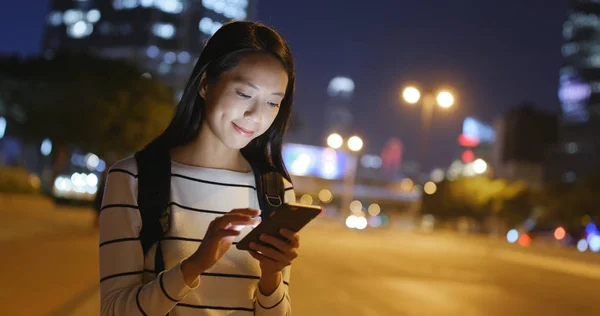 Mulher usando celular à noite — Fotografia de Stock