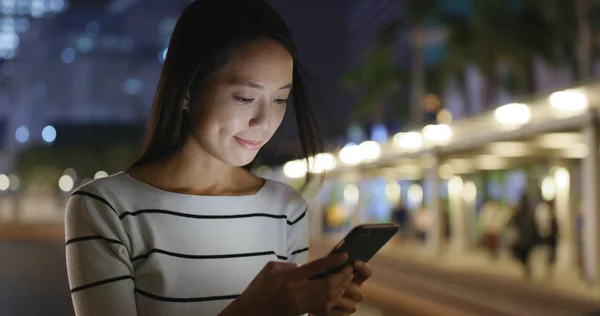 Mulher usando smartphone à noite — Fotografia de Stock