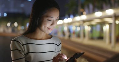 Geceleri cep telefonu kullanan kadın