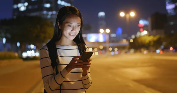 Mujer usando el teléfono móvil por la noche — Foto de Stock